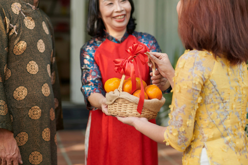 Gift baskets for Mother's Day - Woman handing a gift basket of fruit to another woman