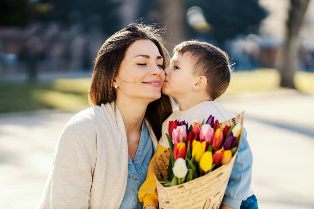 Mother's Day Gifts - Boy kissing mom on cheek holding tulips bouquet