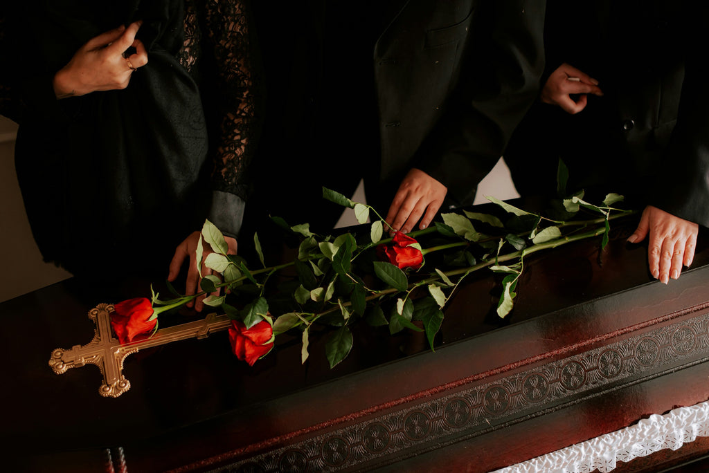 What color flowers for funeral? - Red roses on a brown casket