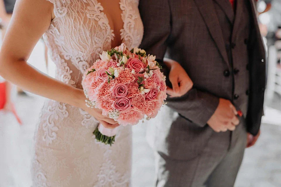 Photo of bride holding a wedding bouquet of roses pink carnations and baby breaths