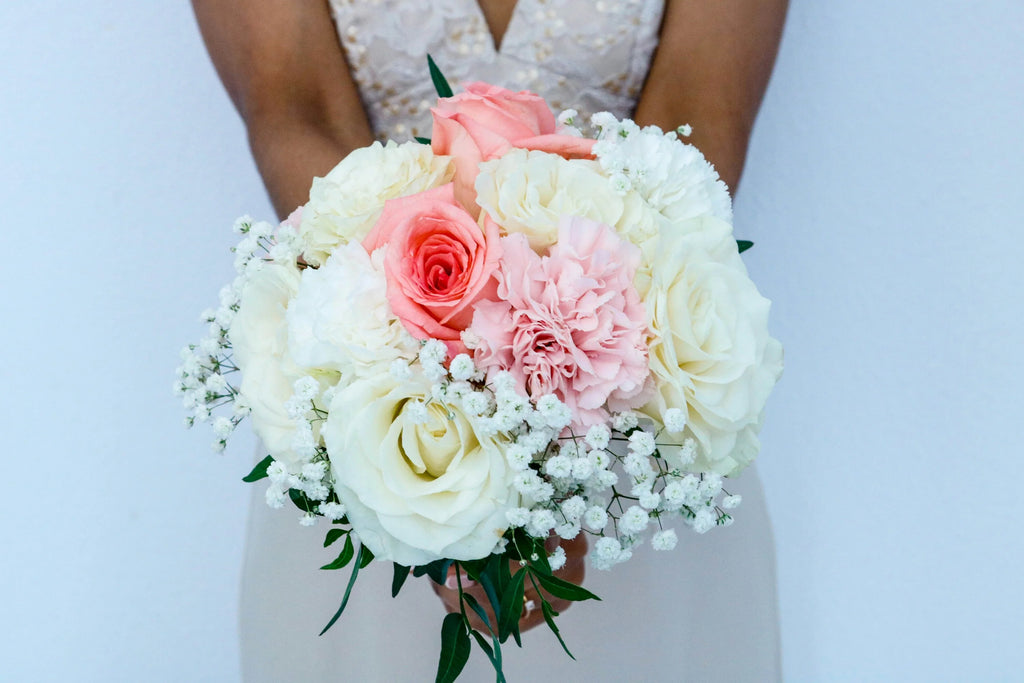 Bride holding rose bouquet with baby's breath