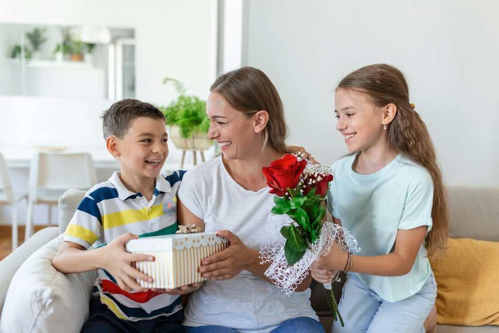 When is Mother's Day in Canada? - Mom sitting with son and daughter who are smiling while giving her gifts