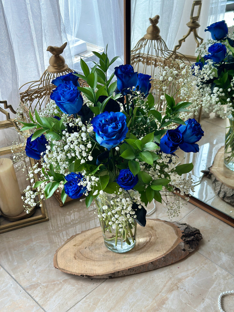 12 blue roses with baby's breath in the vase