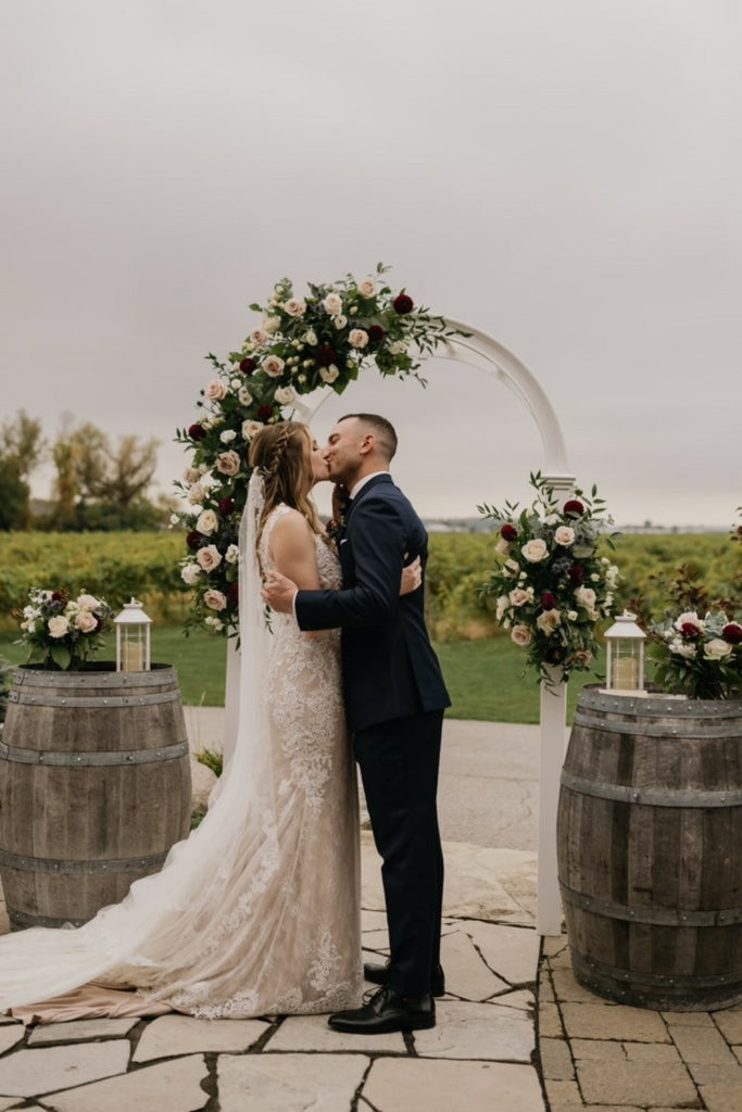 Photo of a bride and groom embracing each other under the altar in an outdoor wedding