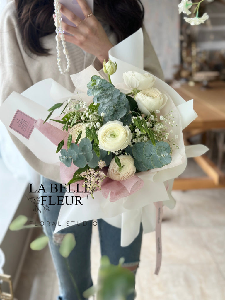 Photo of a woman holding the white ranunculus bouquet by La Belle Fleur