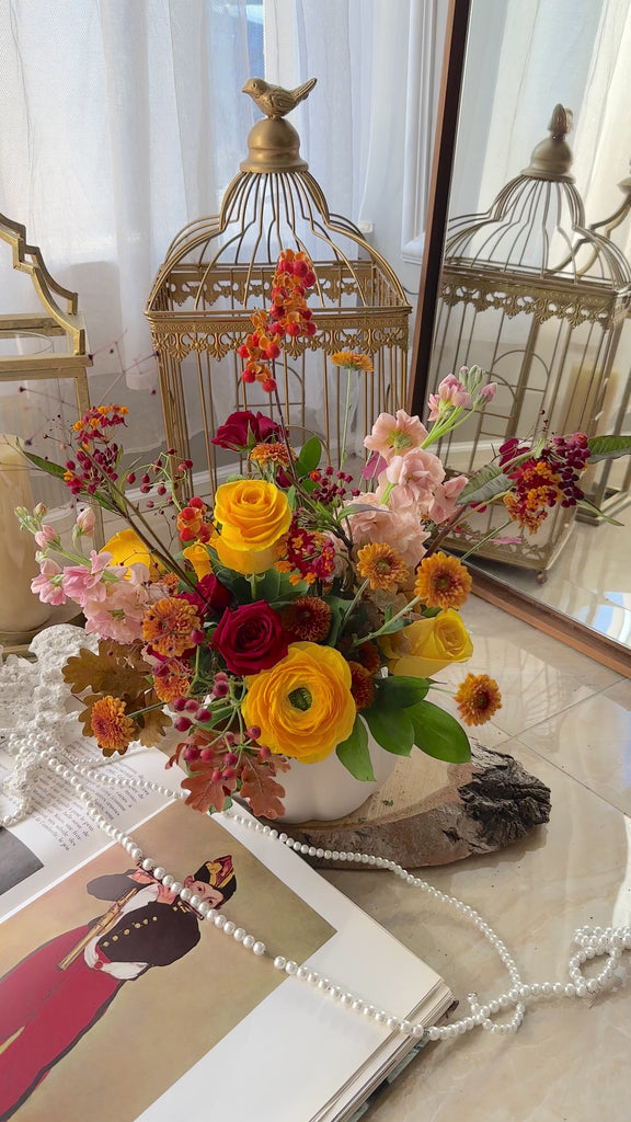 fall arrangement with yellow roses and ranunculus