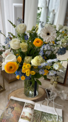 yellow and blue sympathy flower arrangement