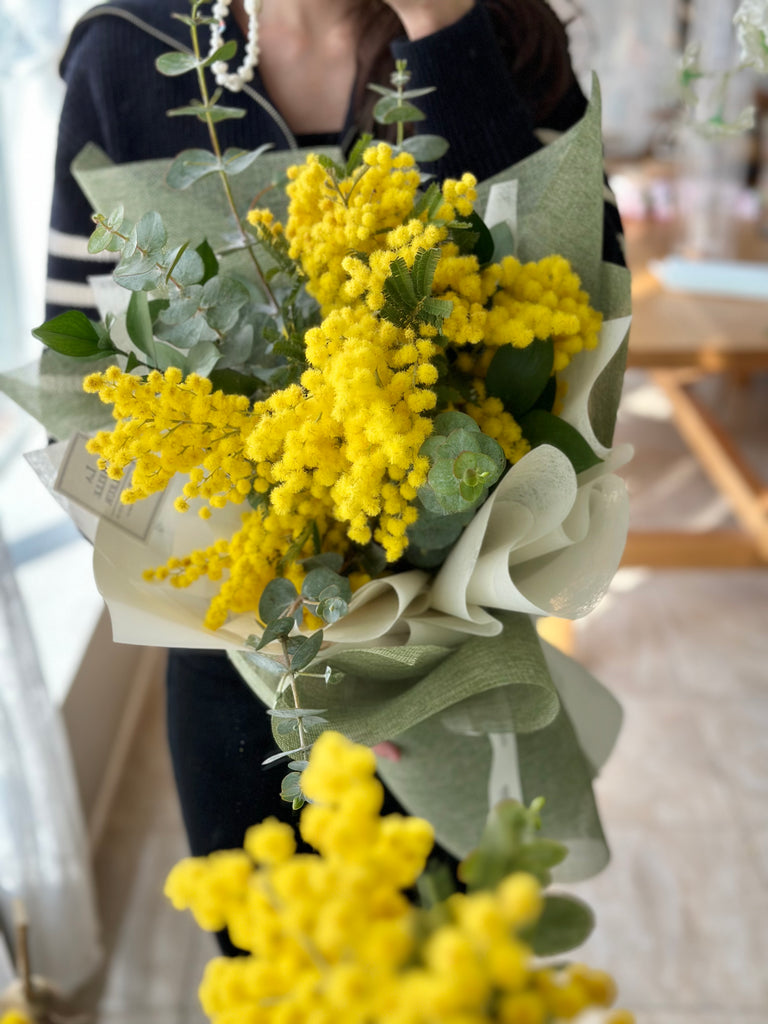 Mimosa flower bouquet with green wrapping